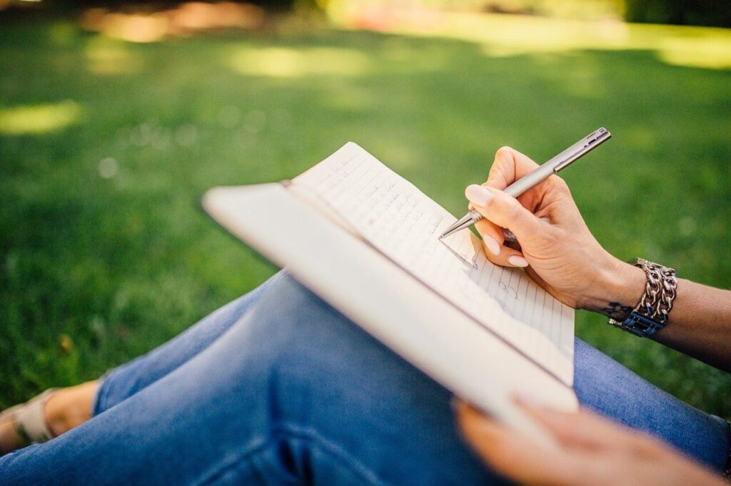 公園で女性がノートに書いている